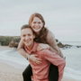 man carrying woman beside seashore